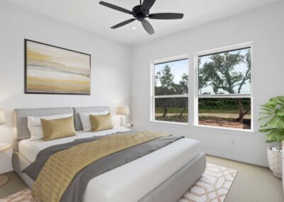 A bright and airy master bedroom with a large window, plush carpet, and ample natural light.