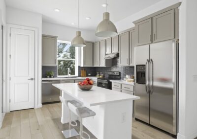 A modern, high-end kitchen with stainless steel appliances, stone countertops, and a large center island.