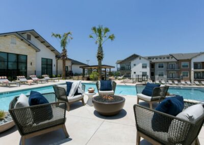 The resort-style swimming pool surrounded by a sundeck, lounge chairs, and comfortable seating areas.