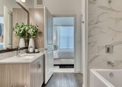 A clean, modern bathroom with a large vanity, a spacious shower, and stylish tile.