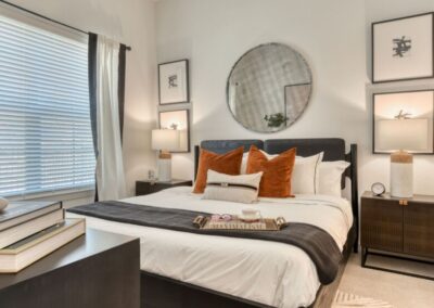 A spacious master bedroom with an attached bathroom and a large window overlooking the grounds.