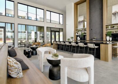 A modern community clubhouse with a resident lounge, a coffee bar, and comfortable seating areas.