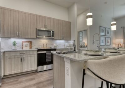 A stylish kitchen with a large center island, a breakfast bar, and a tile backsplash.