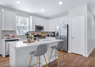 Gourmet chef’s kitchen with quartz countertops, stainless steel appliances, and tile backsplash