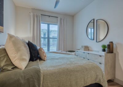 Serene primary suite with expansive windows and neutral designer tones.